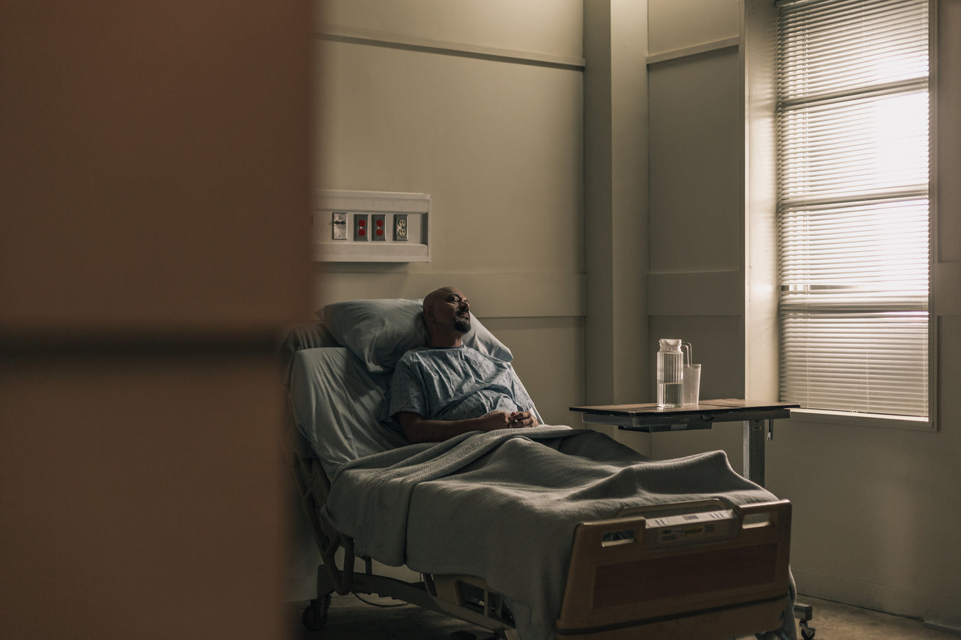 A MALE PATIENT LYING IN HOSPITAL BED